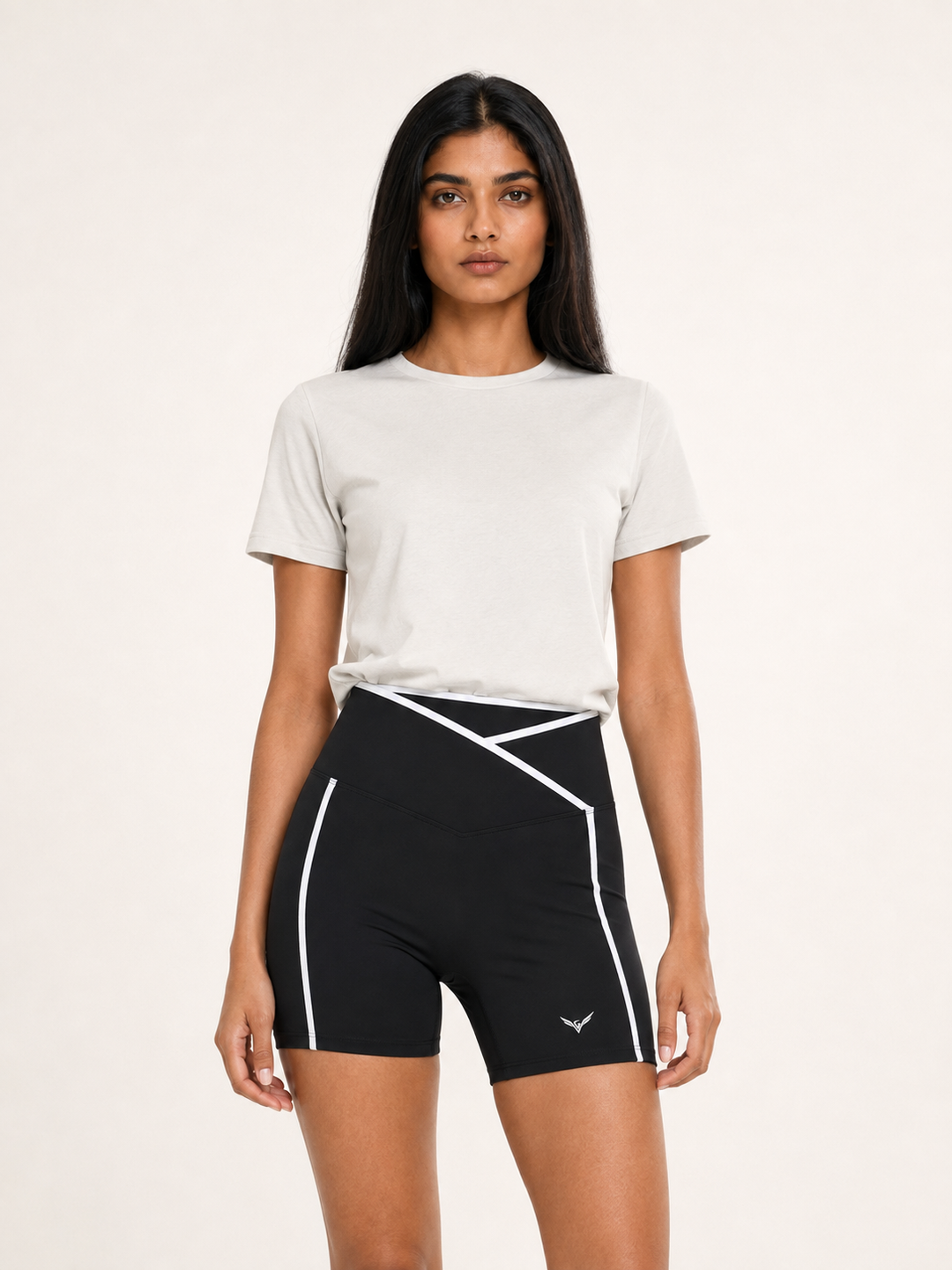 Model wearing black high-rise yoga shorts with white crossover trim, carrying the GALOVTE ornate winged G logo.