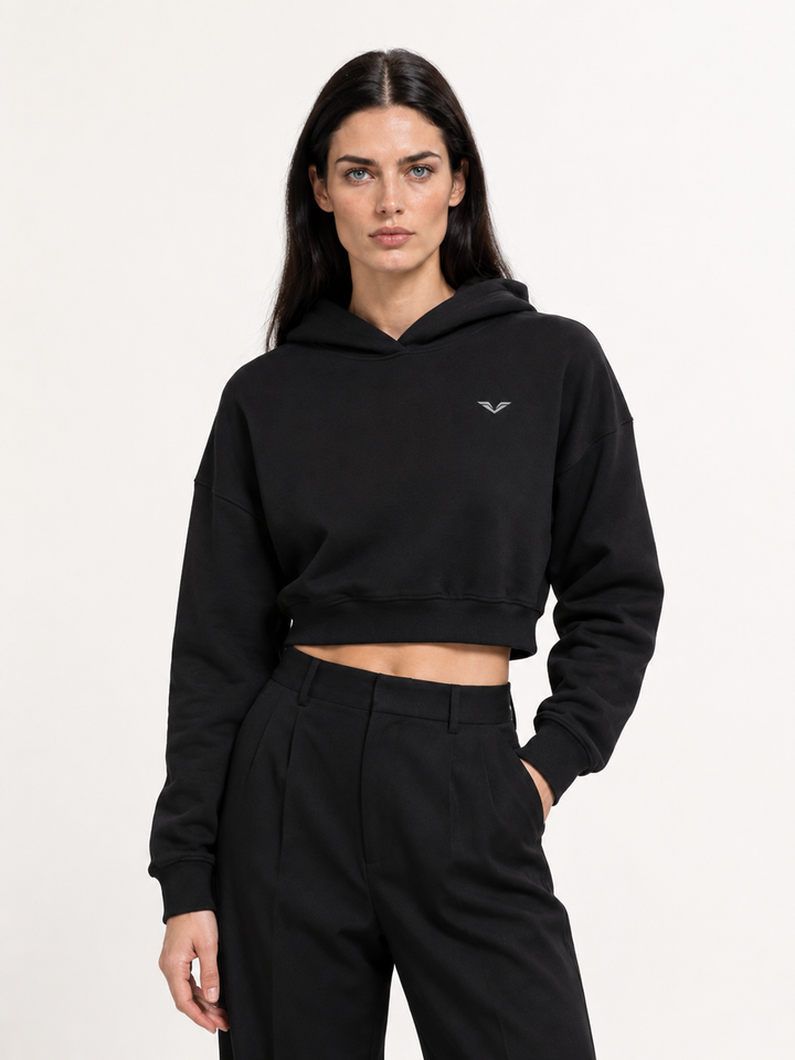Model wearing black cropped pullover hoodie, carrying the GALOVTE winged chevron logo.