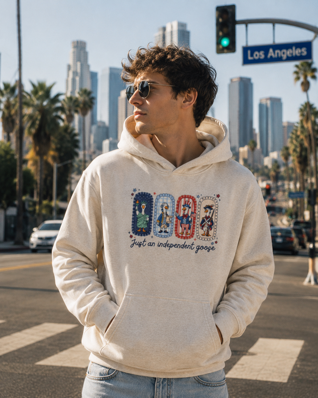 Just An Independent Goose Fourth of July Hoodie in Oat Gray, worn on a Los Angeles street.