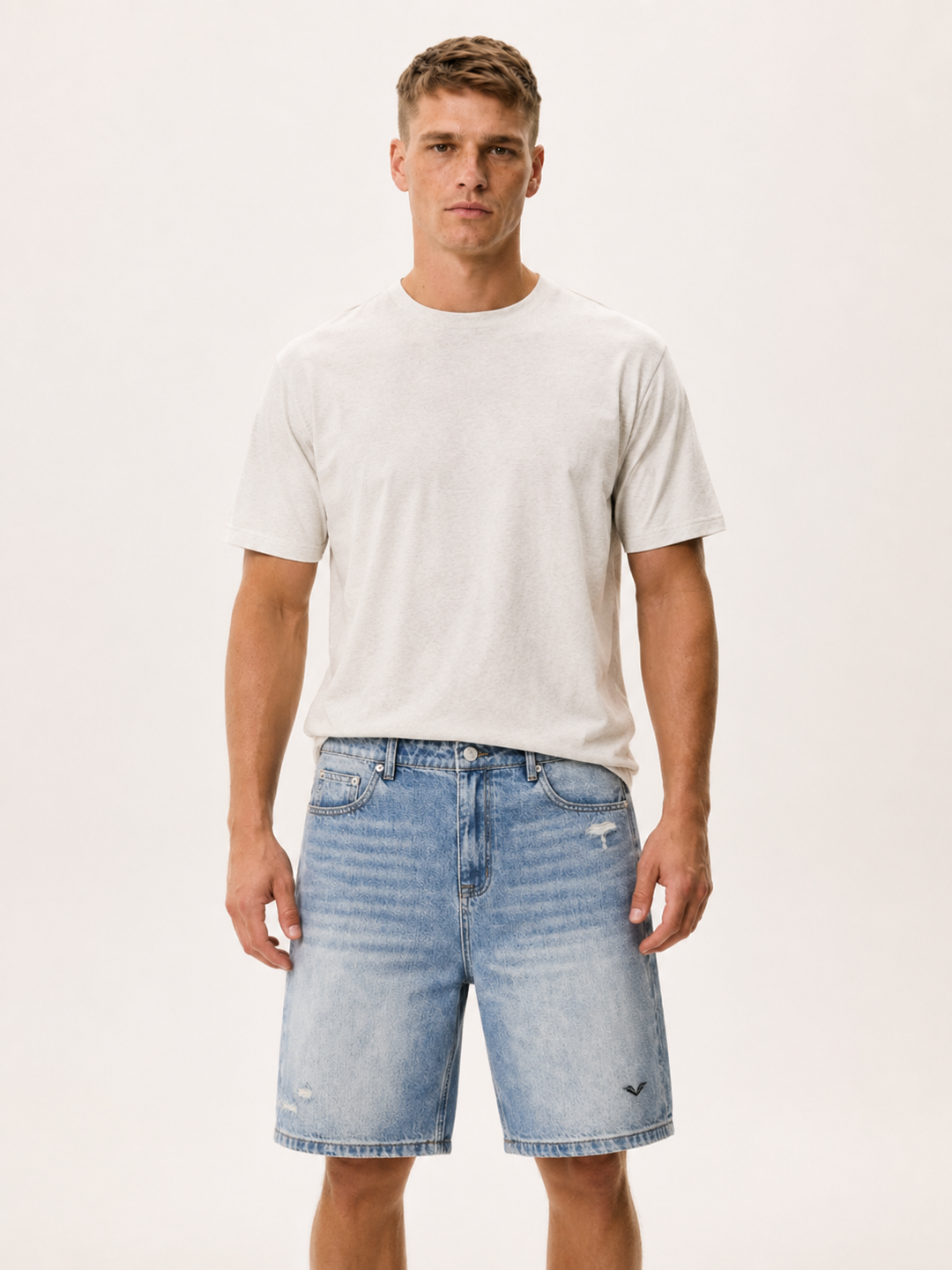 Model wearing faded light blue baggy denim shorts, carrying the GALOVTE winged chevron logo.