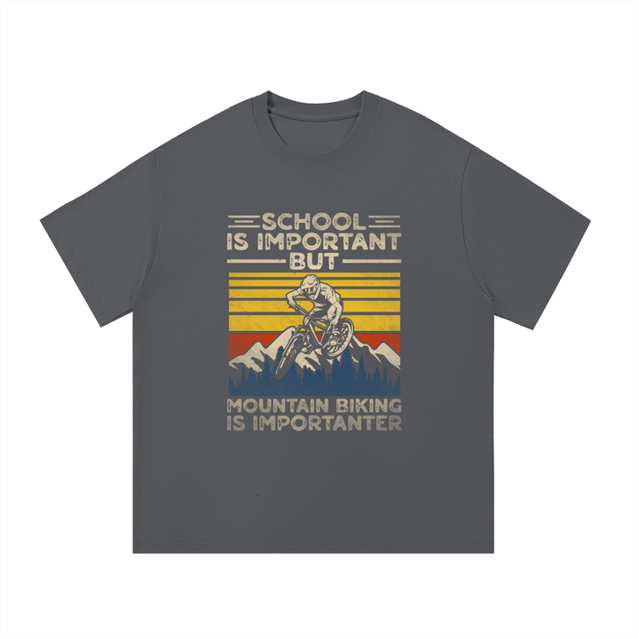 Mountain Biking Is Importanter Funny Tee in Dark Gray, flat lay.