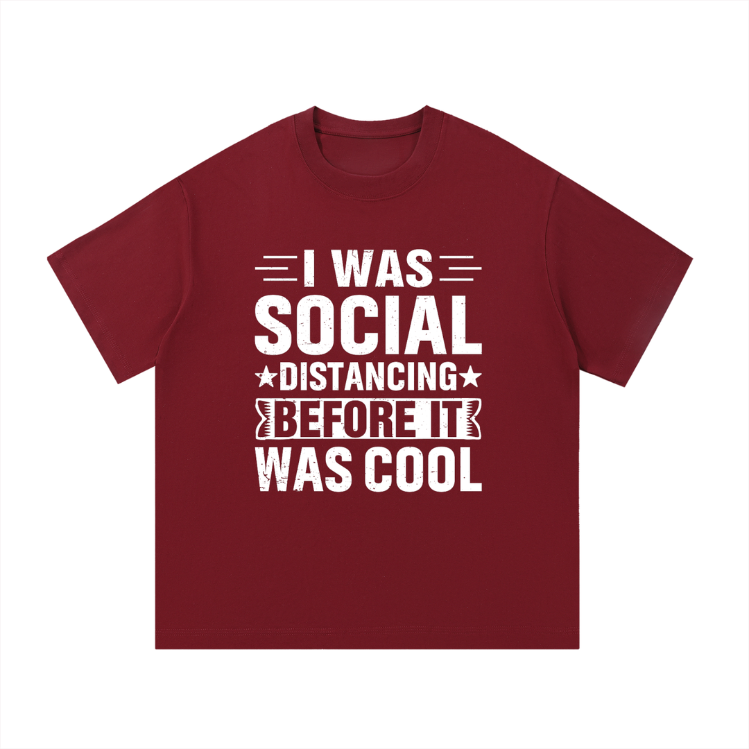 Social Distancing Before It Was Cool Funny Tee in Wine Red, flat lay.