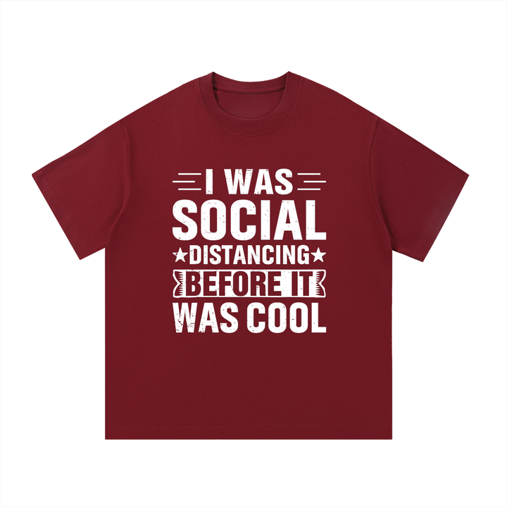 Social Distancing Before It Was Cool Funny Tee in Wine Red, flat lay.