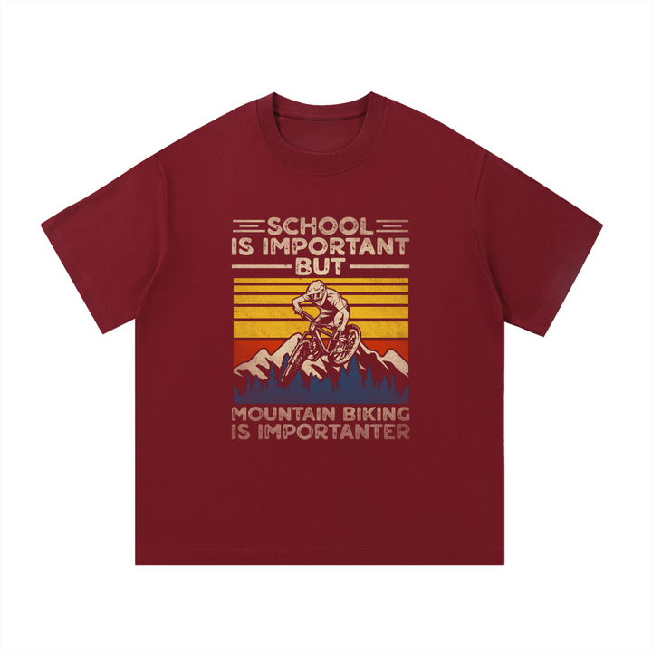 Mountain Biking Is Importanter Funny Tee in Wine Red, flat lay.