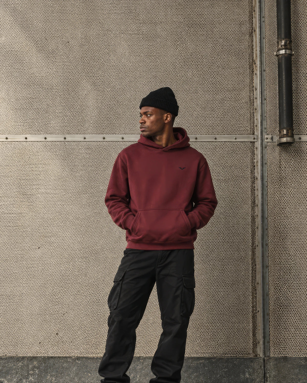 Model in a dull red GALOVTE heavyweight hoodie and black beanie