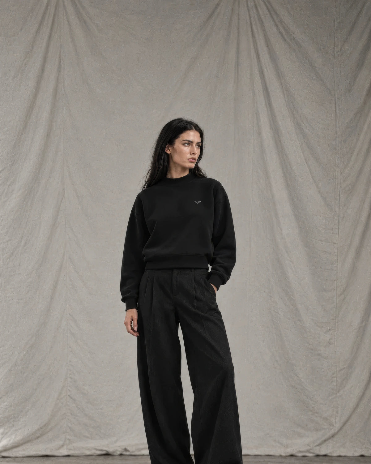 Model in a black GALOVTE fleece mock-neck sweatshirt and wide-leg trousers
